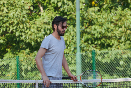 Young man playing tennis on the open courtの写真素材