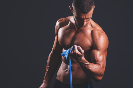 Young bodybuilder working his bicepsの写真素材