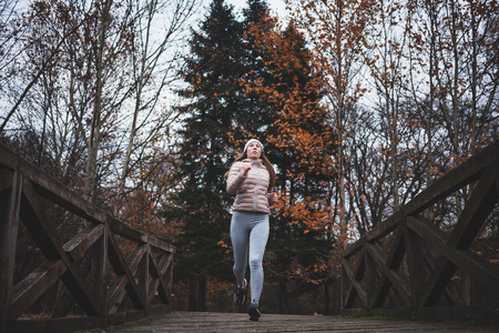 Young woman jogging on a cold day in the parkの写真素材