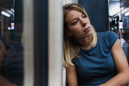 Young woman riding a public bus at nightの写真素材