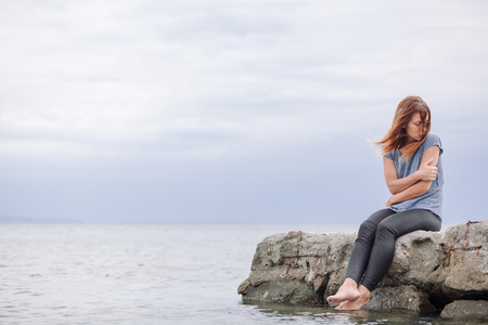 Woman alone and depressed at seasideの写真素材