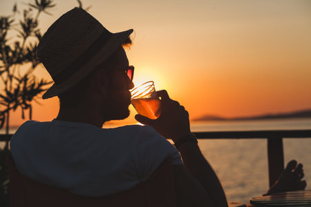 Young man enjoying sunset at a beach bar