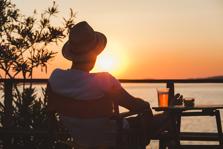 Young man enjoying sunset at a beach barの写真素材
