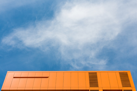 Top of orange building and blue skyの写真素材