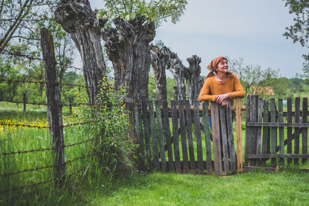Peasant mature woman in yardの写真素材