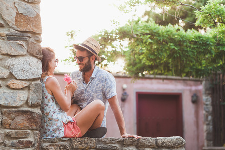 Young couple in love sitting on the wallの写真素材