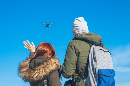 Two couple taking a selfie with a drone, drone navigating
