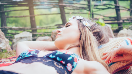 Beautiful hipster girl lying in the gardenの写真素材