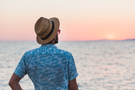 Young man enjoying sunset by the seaの写真素材