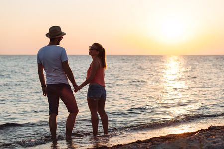 Young couple in love enjoying sunset on the beachの写真素材