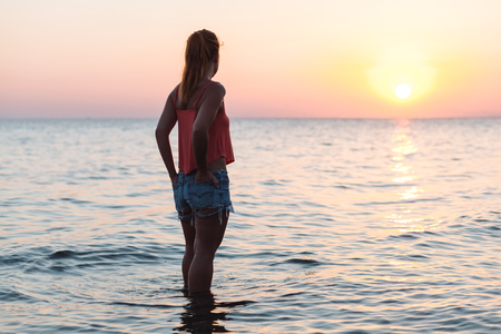 Young woman enjoying sea and sunsetの写真素材