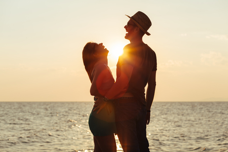 Young couple in love enjoying sunset on the beachの写真素材