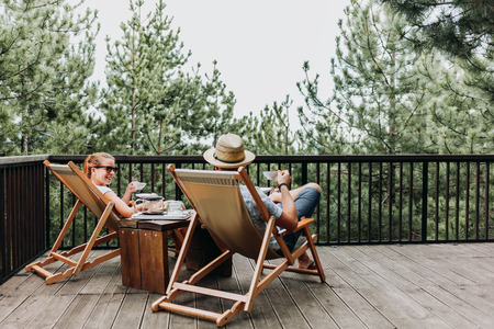 Couple enjoying coffee on a balcony in the mountainsの写真素材