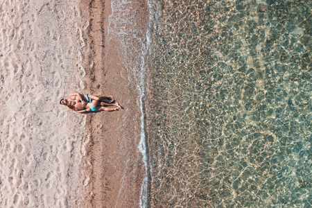 Young couple alone on the beach enjoying the view at the seaの写真素材