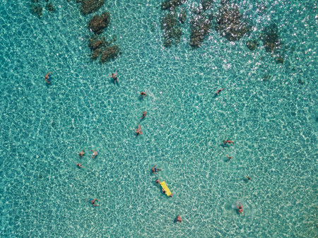 Aerial view of people swimming in the sea in the summer seasonの写真素材