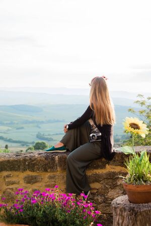 Young woman enjoying the view of beautiful landscape in Tuscany, Italyの写真素材
