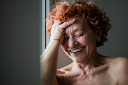 Happy mature woman smiling by the window