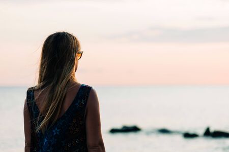Young woman enjoying sunset on the beachの写真素材