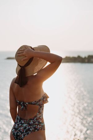 Young woman enjoying sunset by the seaの写真素材