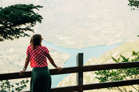 Young female nature explorer enjoying the view from mountain viewpointの写真素材
