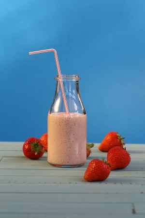Strawberry smoothie with strawberries on blue backgroundの写真素材