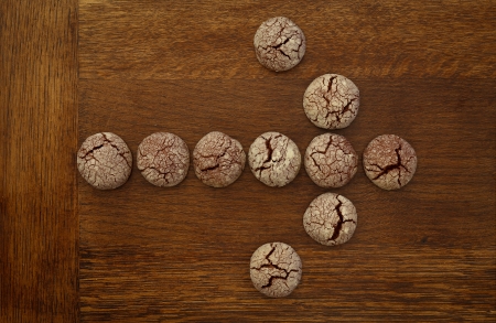 Chocolate cookies arrow sign on wooden boardの写真素材