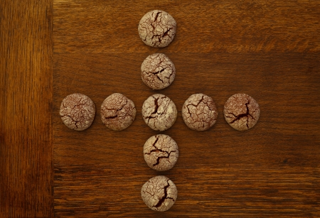 Chocolate cookies plus sign on wooden boardの写真素材