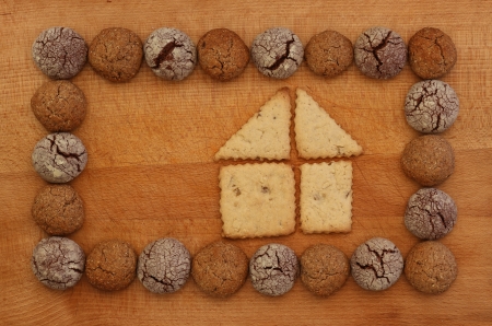 Chocolate and Hazelnut cookies frame on wooden board with house signの写真素材