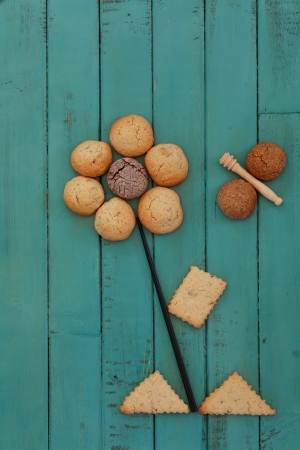 Cookies Stacked as Flower and Bee on Turquoise Wooden Boardの写真素材