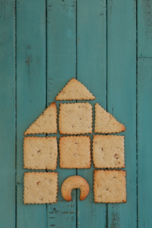 Ginger Cookies Stacked as house on turquoise wooden board, copy spaceの写真素材