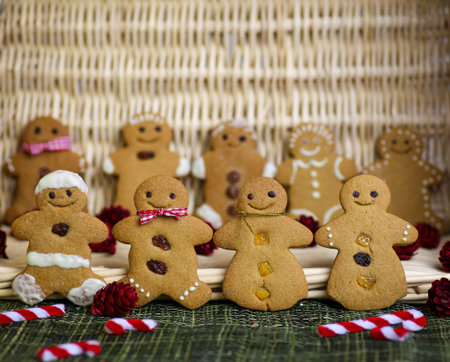 Gingerbread family with gingham ribbons  and christmas decoration, wicker basket in background