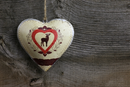 Christmas handmade decoration deer in tin heart over rustic Elm wood background - retro style design, copy spaceの写真素材