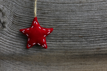 Christmas handmade decoration red fabric star over rustic Elm wood background - retro style design, copy spaceの写真素材