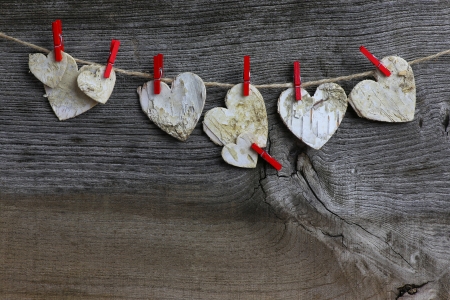 Christmas handmade decoration Birch wooden hearts and red clips over rustic Elm wood background - retro style design, copy spaceの写真素材