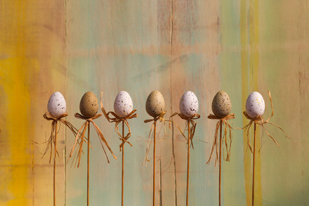 Happy easter text with marbled eggs on sticks and green painted background copy spaceの写真素材