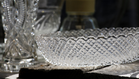 Antique crystal glass bowl and bottle in old shop with backlight from windowの写真素材