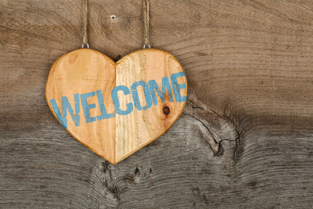 Welcome message wooden heart sign from recycled old palette on rough grey wooden background, copy spaceの写真素材