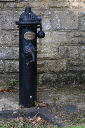 Antique with chain blocked drinking fountain and water pumpの写真素材