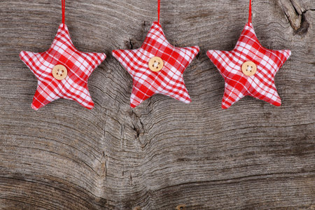 Red fabric star Merry Christmas handmade decoration over rustic Elm wood background - retro style...