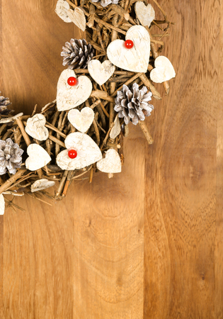 Christmas handmade vintage wreath decoration Shabby Chic white wooden hearts with red berries over wooden background - retro style design, copy spaceの写真素材