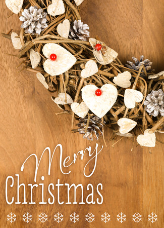 Merry Christmas message, handmade wreath decoration Shabby Chic white wooden hearts with red berries over wooden background - retro style designの写真素材