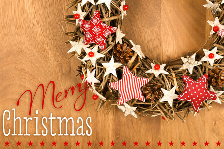 Merry Christmas message, handmade wreath decoration Shabby Chic white wooden stars with red gingham fabric pattern over wooden background - retro style designの写真素材