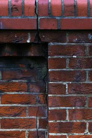 Background of old red vintage grunge brick wall texture with a crackの写真素材