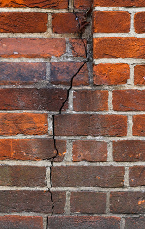 Background of old red vintage grunge brick wall texture with a crack