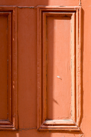 Weathered painted orange wooden door grunge textures and backgroundsの写真素材