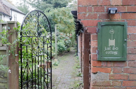 Winslow, Buckinghamshire, United Kingdom, October 25, 2016: Just so cottage B&B front gate with street sign  on the Walk street, Winslow.のeditorial素材