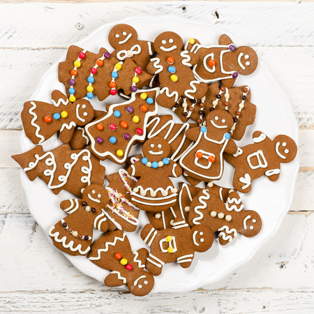 Christmas homemade gingerbread man family cookies couples on white wooden table backgroundの写真素材