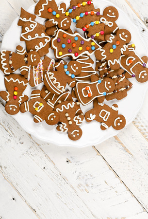 Christmas homemade gingerbread man family cookies couples on white wooden table backgroundの写真素材