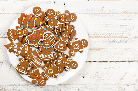 Christmas homemade gingerbread man family cookies couples on white wooden table backgroundの写真素材