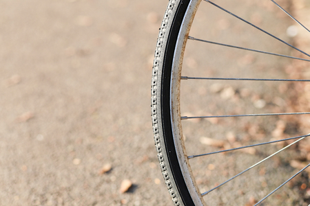 Close up shot of old bicycle wheel rim with tire on light brown backgroundの写真素材